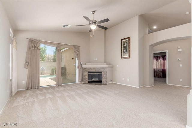 8266 Lincoln Valley St, Las Vegas, NV 89123 - unfurnished living room featuring ceiling fan, a fireplace, carpet floors, arched walkways, and baseboards