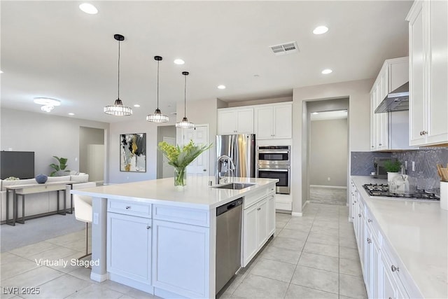 701 Monroe Hill Pl, Henderson, NV 89011 - kitchen with appliances with stainless steel finishes, light tile patterned floors, exhaust hood, decorative backsplash, and a breakfast bar