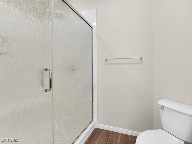 6465 Grande River Ct, Las Vegas, NV 89139 - bathroom with wood finished floors, baseboards, toilet, and a stall shower
