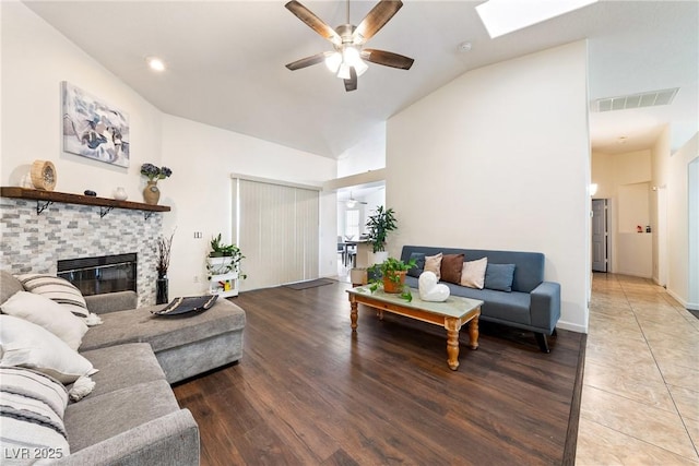 3481 Winery Rd, Pahrump, NV 89048 - living area with ceiling fan, a fireplace, wood finished floors, high vaulted ceiling, and a skylight