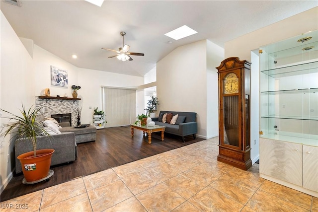 3481 Winery Rd, Pahrump, NV 89048 - tiled living room with lofted ceiling, a skylight, a fireplace, a ceiling fan, and recessed lighting
