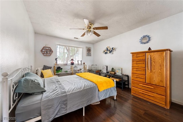 3481 Winery Rd, Pahrump, NV 89048 - bedroom featuring dark wood-style flooring, a textured ceiling, and a ceiling fan