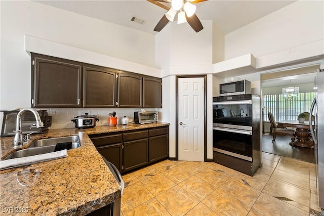 3481 Winery Rd, Pahrump, NV 89048 - kitchen with appliances with stainless steel finishes, a sink, dark brown cabinetry, a ceiling fan, and light tile patterned flooring