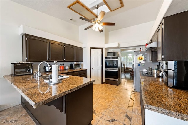 3481 Winery Rd, Pahrump, NV 89048 - kitchen featuring a sink, appliances with stainless steel finishes, a peninsula, ceiling fan, and dark brown cabinets