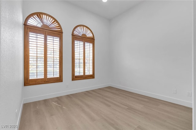 empty room with light wood finished floors and baseboards