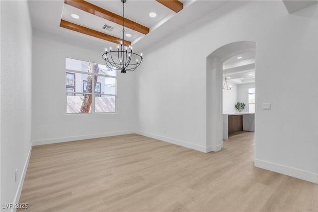 spare room featuring arched walkways, a raised ceiling, light wood-style flooring, a chandelier, and beamed ceiling