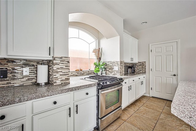 6409 Shawnee Springs Ct, Las Vegas, NV 89139 - kitchen featuring gas range, white cabinetry, backsplash, tile countertops, and light tile patterned floors