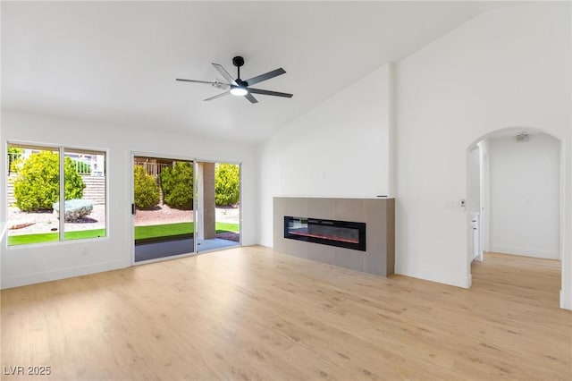 2913 Hawksdale Dr, Las Vegas, NV 89134 - unfurnished living room with wood finished floors, high vaulted ceiling, a fireplace, a ceiling fan, and arched walkways