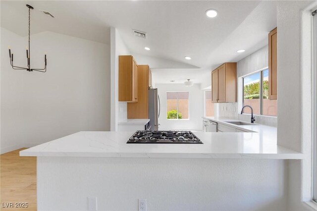 2913 Hawksdale Dr, Las Vegas, NV 89134 - kitchen with a sink, stainless steel appliances, vaulted ceiling, a chandelier, and light wood-style flooring