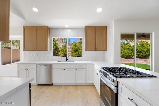 2913 Hawksdale Dr, Las Vegas, NV 89134 - kitchen featuring stainless steel appliances, a sink, backsplash, light wood finished floors, and recessed lighting