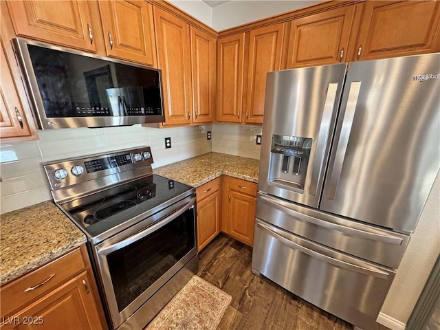 3938 E Chaffe Ave, Pahrump, NV 89061 - kitchen with stainless steel appliances, dark wood finished floors, brown cabinets, backsplash, and light stone counters