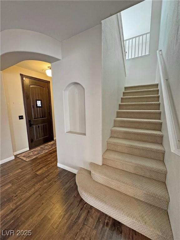 3938 E Chaffe Ave, Pahrump, NV 89061 - entrance foyer featuring arched walkways, stairway, dark wood finished floors, and baseboards