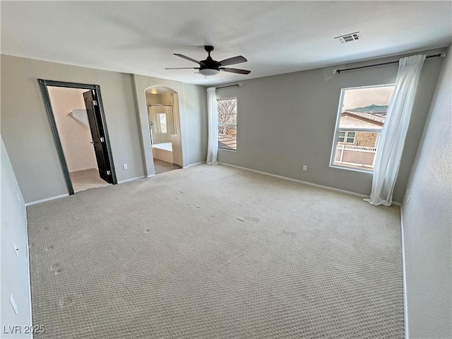 3938 E Chaffe Ave, Pahrump, NV 89061 - unfurnished bedroom with arched walkways, baseboards, ensuite bathroom, carpet, and a spacious closet