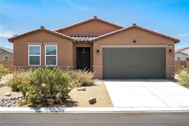3543 E Malheur Ave, Pahrump, NV 89061 - view of front facade with a tile roof, stucco siding, an attached garage, and concrete driveway