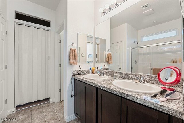 3543 E Malheur Ave, Pahrump, NV 89061 - full bathroom featuring a stall shower, double vanity, baseboards, and tile patterned floors
