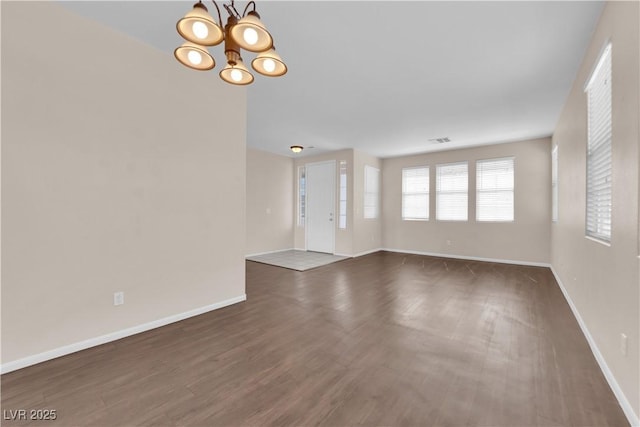 82 Autumn Day St, Henderson, NV 89012 - unfurnished living room with a chandelier, wood finished floors, and baseboards