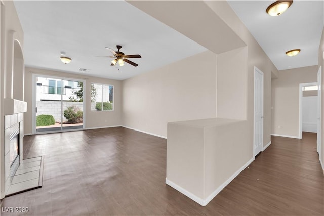82 Autumn Day St, Henderson, NV 89012 - unfurnished living room featuring ceiling fan, wood finished floors, baseboards, and a tile fireplace