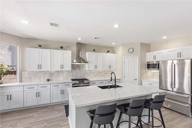 191 Reed Ln, Henderson, NV 89074 - kitchen with appliances with stainless steel finishes, wall chimney range hood, a sink, a kitchen bar, and backsplash