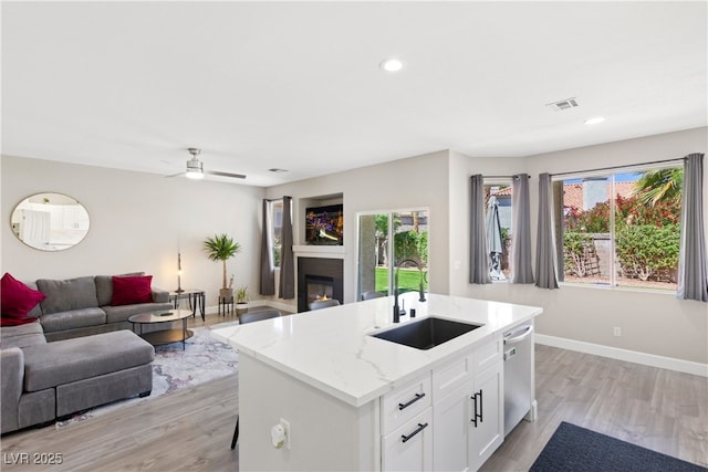 191 Reed Ln, Henderson, NV 89074 - kitchen featuring a sink, stainless steel dishwasher, open floor plan, light wood-style flooring, and a ceiling fan