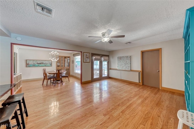 1721 E Oakey Blvd, Las Vegas, NV 89104 - living area featuring a textured ceiling, a ceiling fan, light wood-style flooring, french doors, and a chandelier
