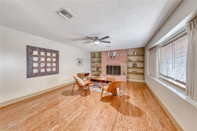 1721 E Oakey Blvd, Las Vegas, NV 89104 - living area with wood finished floors, a textured ceiling, a ceiling fan, built in shelves, and baseboards