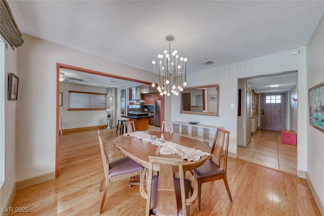 1721 E Oakey Blvd, Las Vegas, NV 89104 - dining room with light wood-type flooring, baseboards, a chandelier, and a textured ceiling