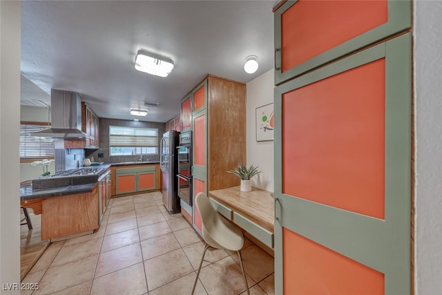 1721 E Oakey Blvd, Las Vegas, NV 89104 - kitchen featuring wall chimney range hood, light tile patterned floors, freestanding refrigerator, and a sink