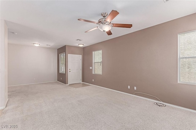spare room featuring ceiling fan, baseboards, and light carpet