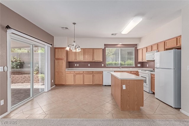 kitchen featuring white appliances, light countertops, a chandelier, and healthy amount of natural light