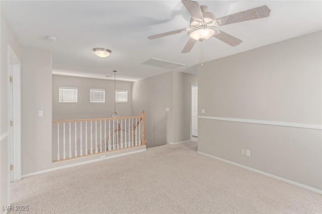 carpeted empty room with ceiling fan and baseboards