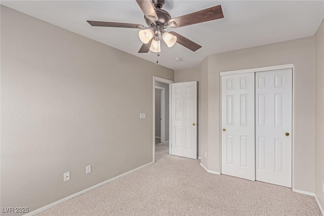 unfurnished bedroom with carpet flooring, baseboards, a closet, and ceiling fan