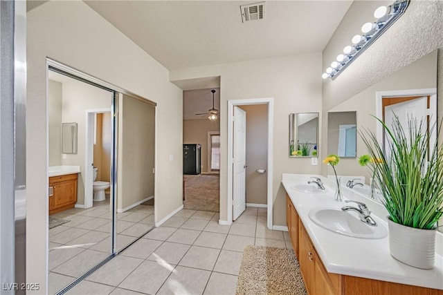2309 Tedesca Dr, Henderson, NV 89052 - full bath with double vanity, baseboards, a ceiling fan, toilet, and tile patterned floors