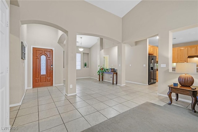 2309 Tedesca Dr, Henderson, NV 89052 - foyer entrance featuring light tile patterned floors, arched walkways, baseboards, and a towering ceiling