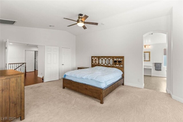 2940 Cimini Ct, Henderson, NV 89052 - carpeted bedroom featuring arched walkways, vaulted ceiling, baseboards, a ceiling fan, and connected bathroom