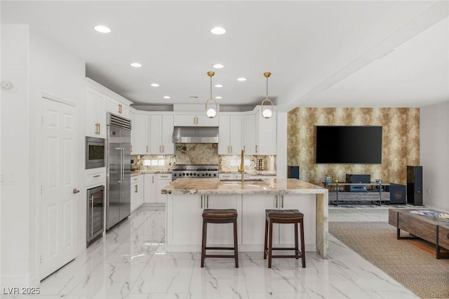 2940 Cimini Ct, Henderson, NV 89052 - kitchen featuring built in appliances, under cabinet range hood, recessed lighting, beverage cooler, and a sink