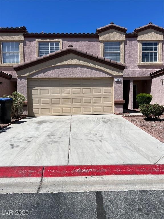 view of front of home featuring a tile roof, stucco siding, and concrete driveway