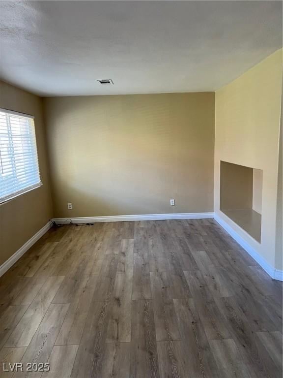 empty room featuring wood finished floors and baseboards