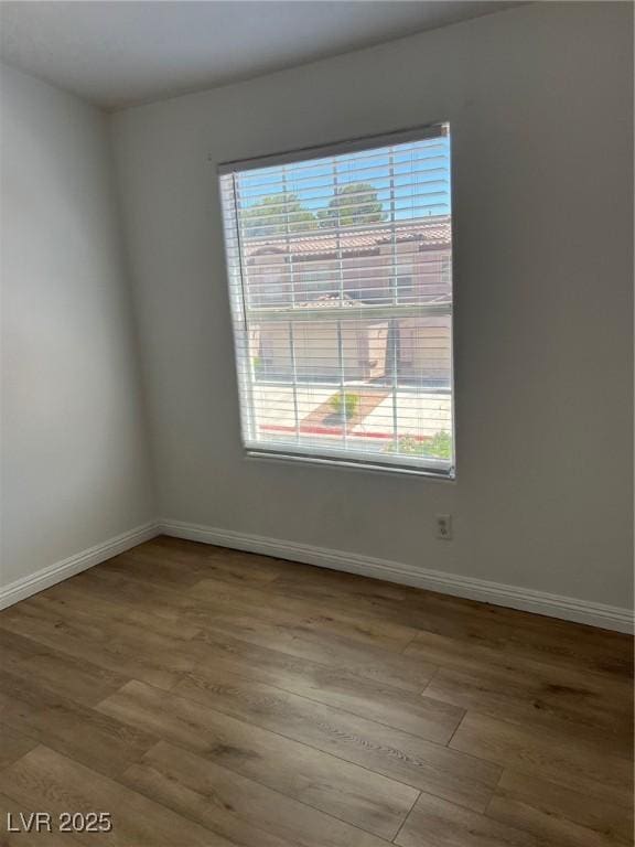 spare room with wood finished floors and baseboards
