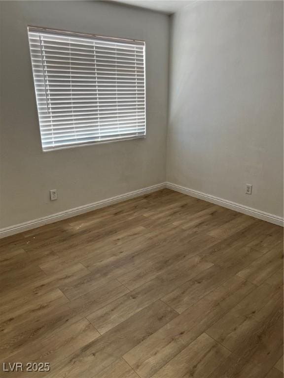 unfurnished room featuring wood finished floors and baseboards