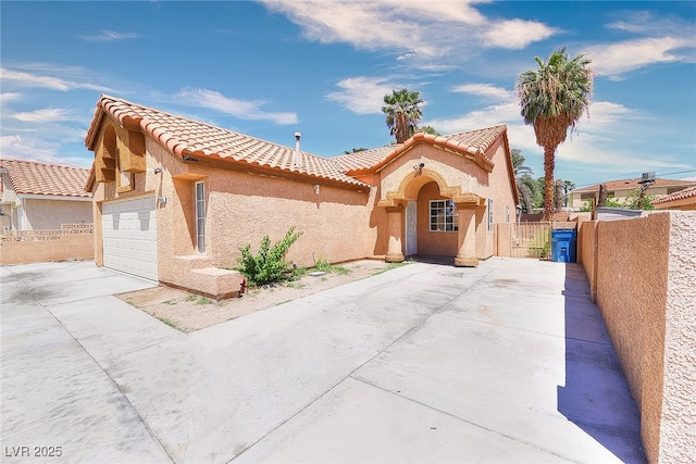 5536 Cleary Ct, Las Vegas, NV 89108 - mediterranean / spanish house with a tile roof, concrete driveway, stucco siding, and a garage