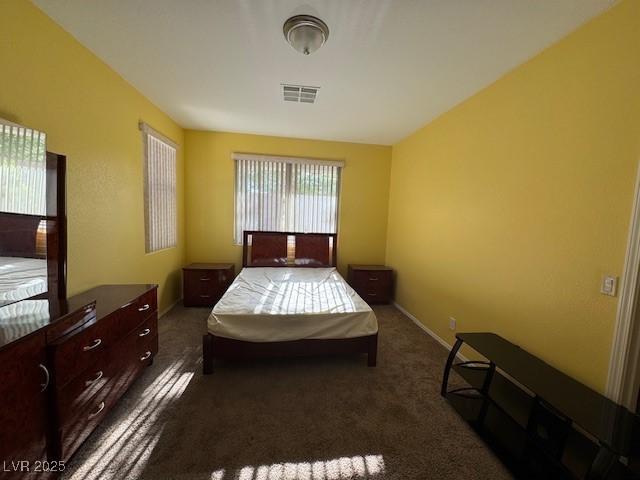 bedroom featuring dark colored carpet and baseboards