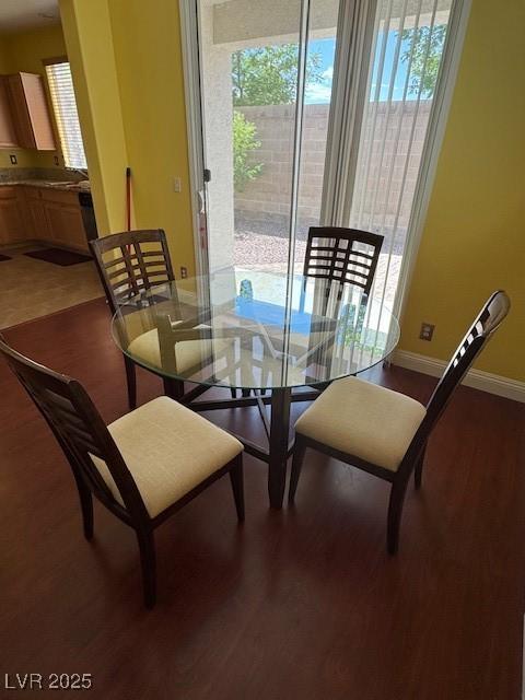dining area featuring healthy amount of natural light, wood finished floors, and baseboards