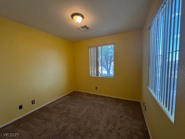 8325 Aspen Village St, Las Vegas, NV 89113 - empty room with dark colored carpet and a textured ceiling