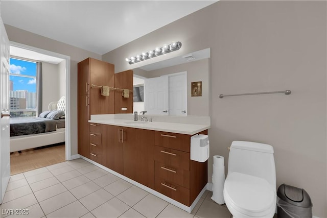 200 W Sahara Ave Unit 603, Las Vegas, NV 89102 - bathroom featuring vanity, baseboards, tile patterned floors, toilet, and ensuite bathroom