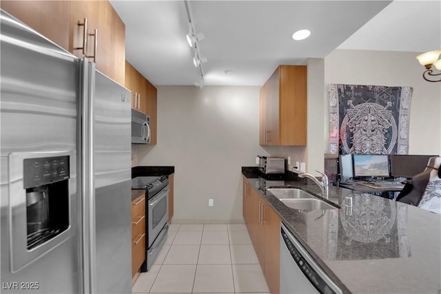 200 W Sahara Ave Unit 603, Las Vegas, NV 89102 - kitchen featuring appliances with stainless steel finishes, a sink, brown cabinetry, track lighting, and dark stone countertops