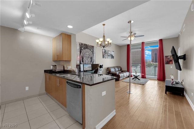 200 W Sahara Ave Unit 603, Las Vegas, NV 89102 - kitchen featuring stainless steel dishwasher, a peninsula, open floor plan, a ceiling fan, and baseboards
