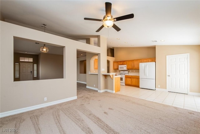 8205 Harrogate Ave, Las Vegas, NV 89129 - unfurnished living room with vaulted ceiling, baseboards, light colored carpet, ceiling fan, and light tile patterned floors