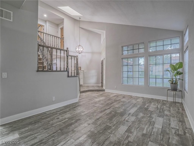 5452 Big Sky Ln, Las Vegas, NV 89149 - unfurnished living room featuring a skylight, stairway, wood finished floors, a chandelier, and baseboards