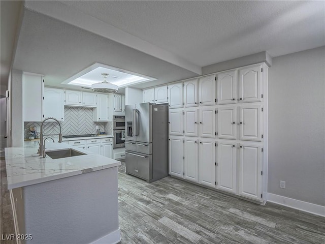5452 Big Sky Ln, Las Vegas, NV 89149 - kitchen featuring appliances with stainless steel finishes, a sink, white cabinetry, light stone counters, and tasteful backsplash
