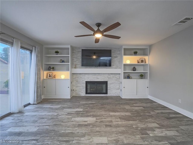 5452 Big Sky Ln, Las Vegas, NV 89149 - unfurnished living room featuring ceiling fan, built in features, a fireplace, and wood finished floors